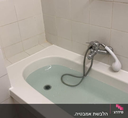 אמבטיה עם מים, ברז ומקלחת יד